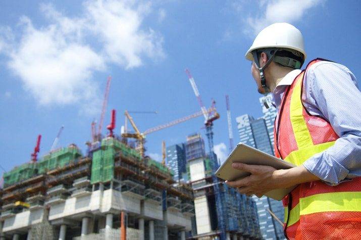 Inspektur keselamatan K3 melakukan observasi lapangan di area proyek konstruksi bangunan